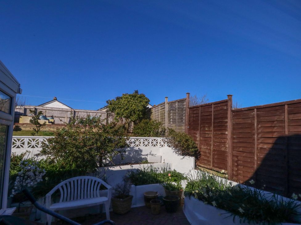 A garden with a wooden fence and flower pots at 46 Chafeys Avenue