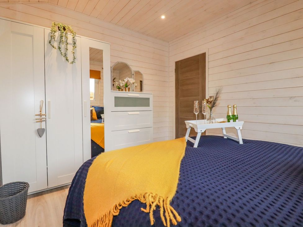 A bedroom with a bed and dresser at St. Chad's Lodge Bodmin