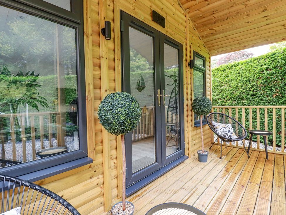 An outdoor terrace with double doors and topiary plant at St. Chad's Lodge Bodmin