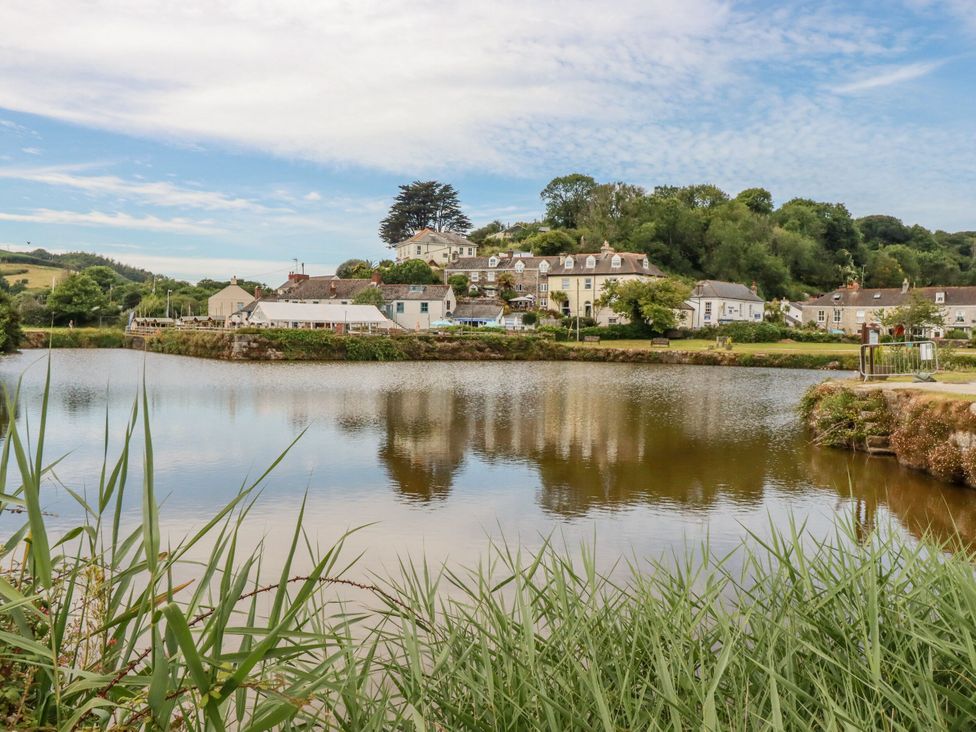 A view of buildings beside a water body at St. Chad's Lodge Luxulyan
