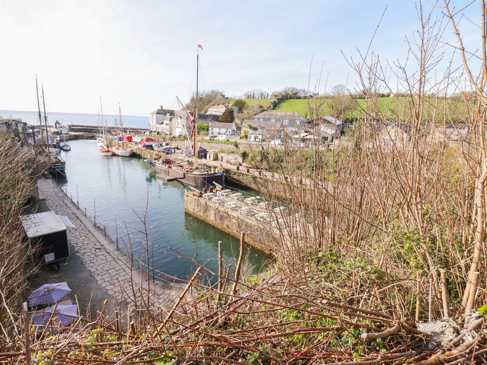 A view of boats in a harbor with buildings and hills at St. Chad's Lodge in Luxulyan