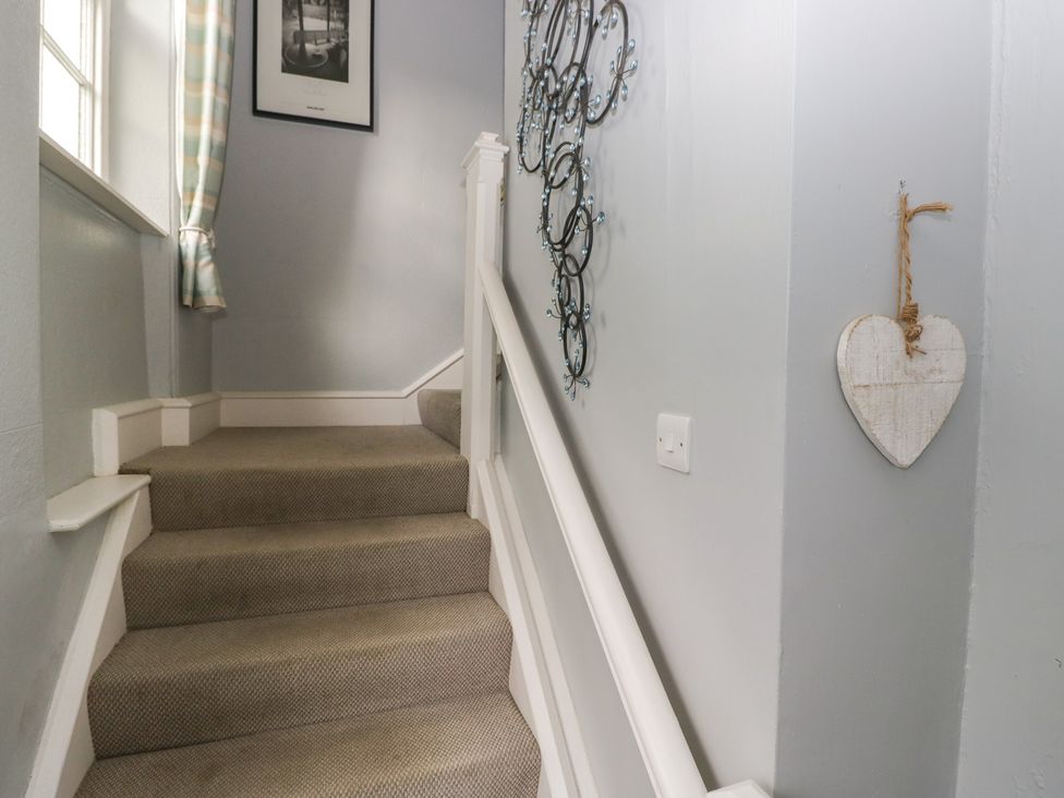 A staircase with a wall decoration and a curtain at Flat 4 Tower House Grange-Over-Sands