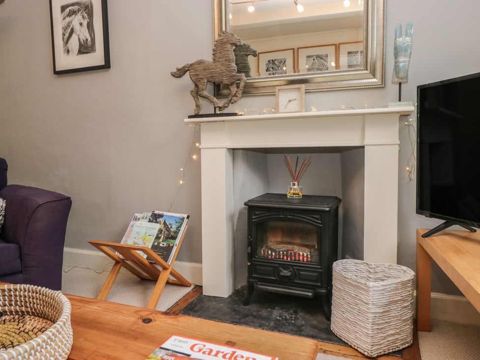 A living room with a fireplace and magazines at Flat 4 Tower House in Grange-Over-Sands