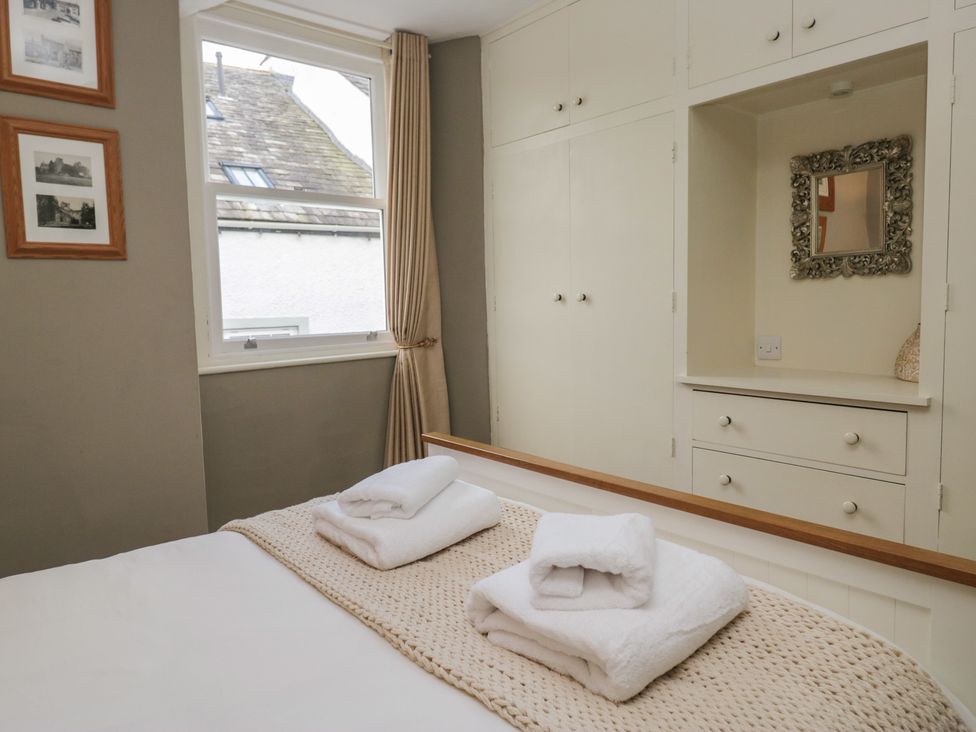 A bedroom with a bed and towels at Flat 4 Tower House Grange-Over-Sands