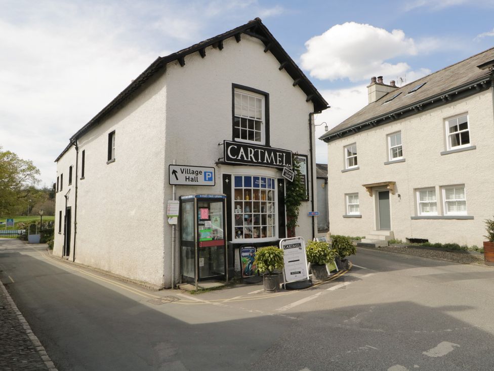 A shop with a sign and a telephone box at Flat 4 Tower House in Grange-Over-Sands