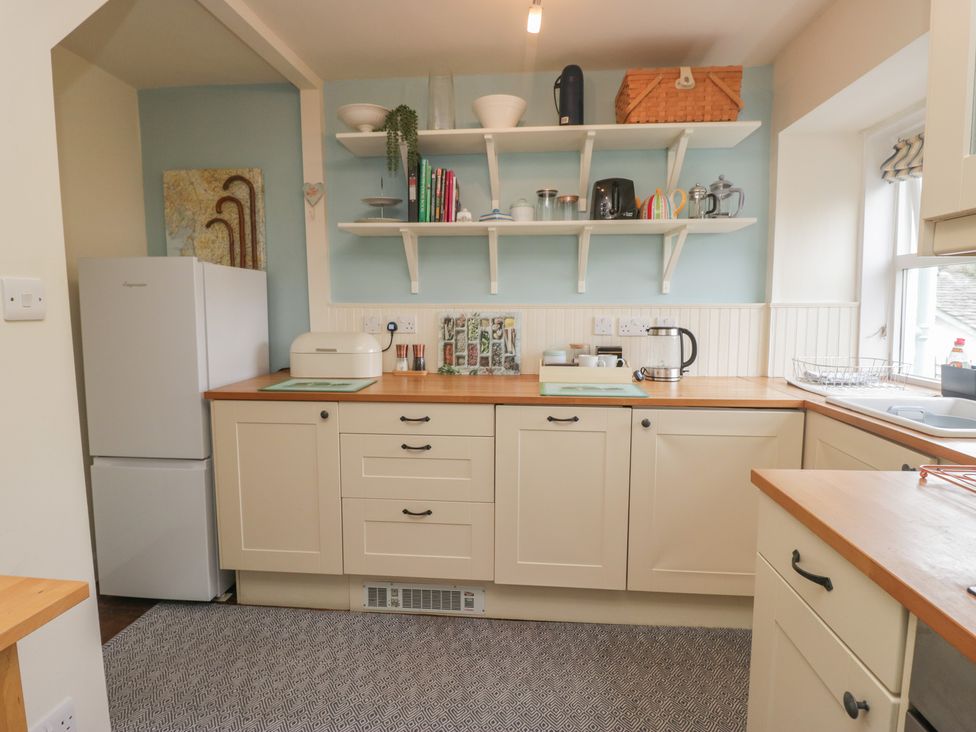 A kitchen with shelves and appliances at Flat 4 Tower House in Cartmel