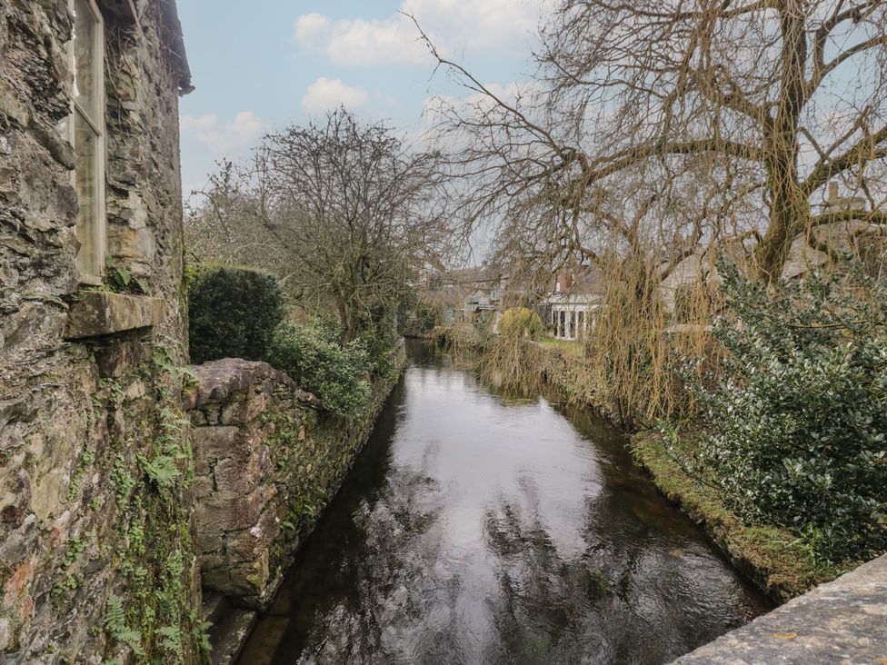 A river with stone walls and trees at Flat 4 Tower House in Cartmel