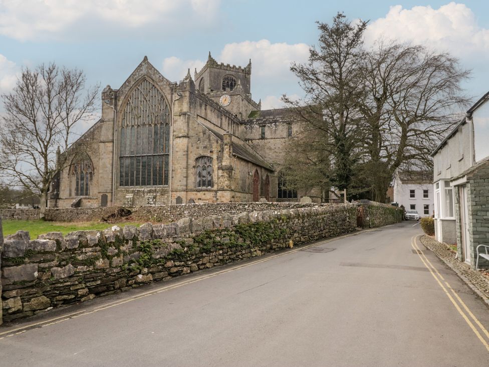 A church building near a road with trees and stone walls at Flat 4 Tower House in Cartmel