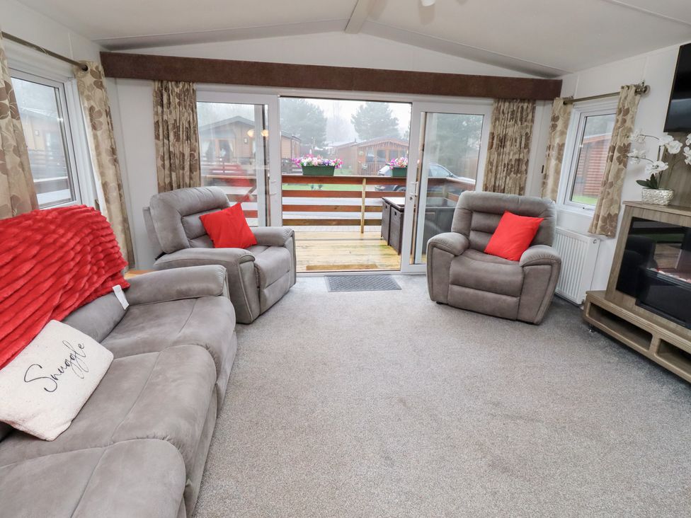A living room with sofas and a television at Chloe's Cabin near Felmoor Holiday Park near Felton