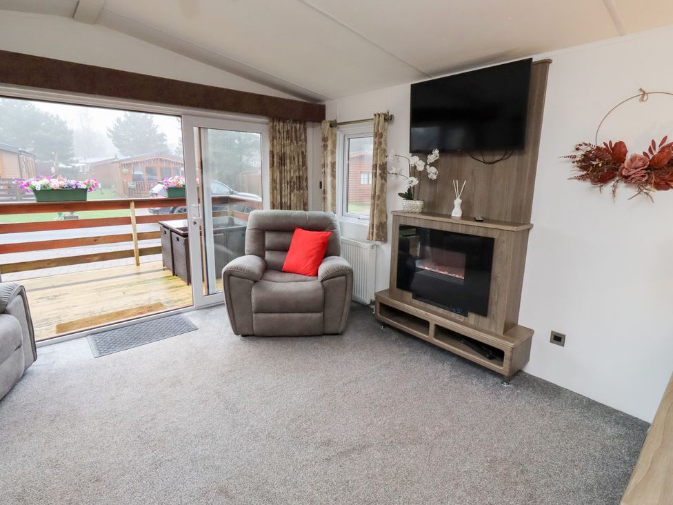 A living room with a recliner chair and television at Chloe's Cabin Felmoor Holiday Park near Felton