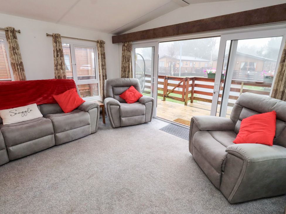 A living room with two armchairs and a sofa at Chloe's Cabin near Felmoor Holiday Park