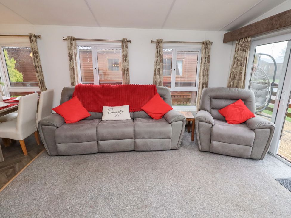 A living room with a sofa and armchair at Chloe's Cabin near Felmoor Holiday Park near Felton