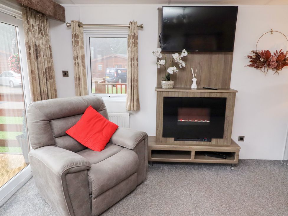 A living room with a chair and television at Chloe's Cabin near Felmoor Holiday Park near Felton
