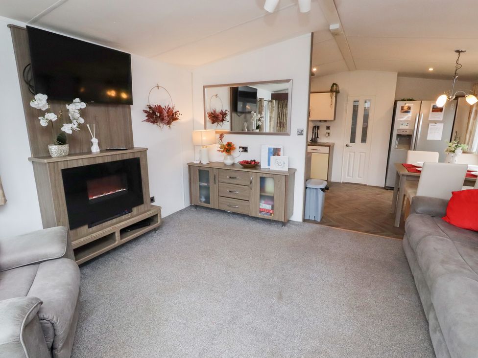 A living room with a television and fireplace at Chloe's Cabin near Felmoor Holiday Park near Felton