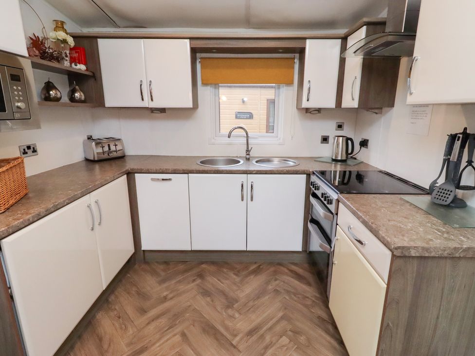 A kitchen with a sink and oven at Chloe's Cabin near Felmoor Holiday Park