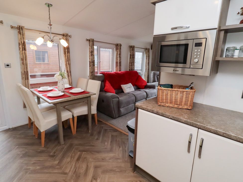 A dining area with a table and chairs at Chloe's Cabin near Felmoor Holiday Park near Felton