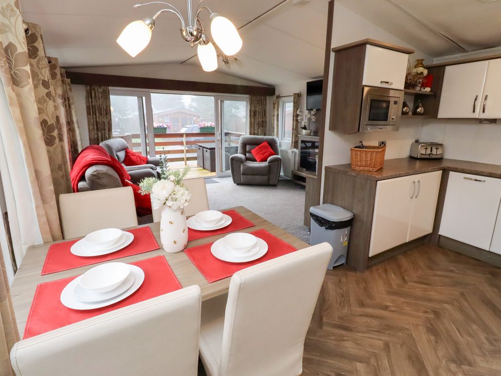 A dining area with a table and chairs at Chloe's Cabin near Felmoor Holiday Park near Felton