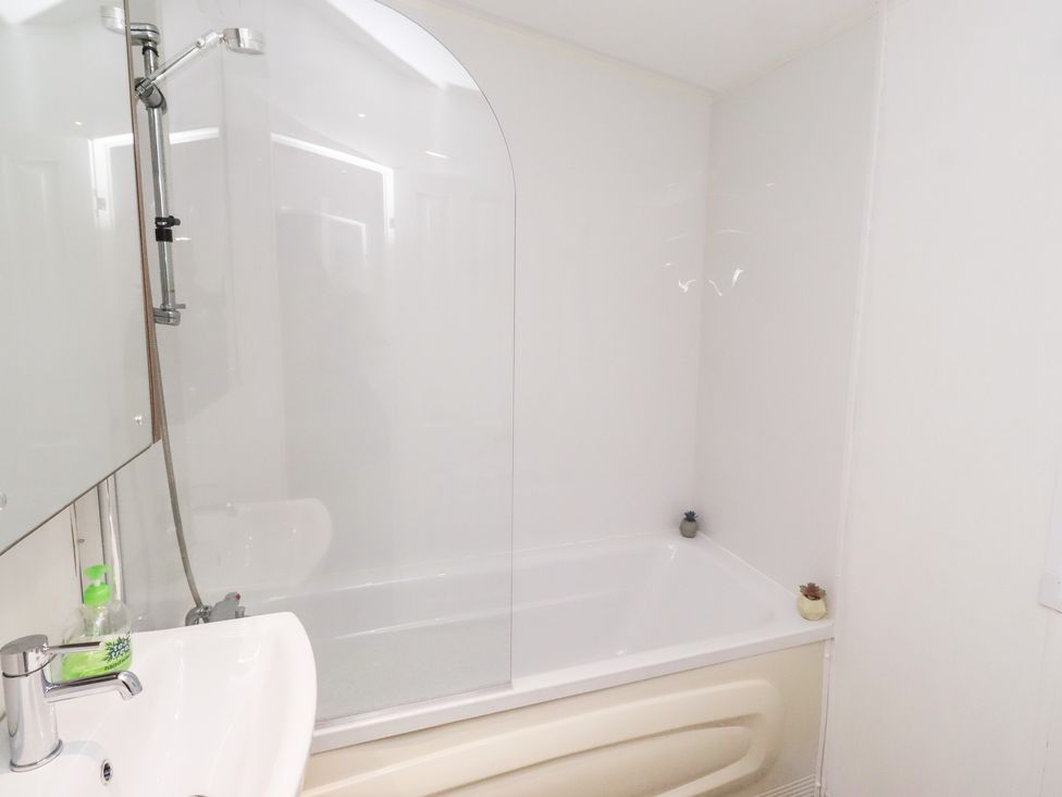 A bathroom with a bathtub and sink at Chloe's Cabin near Felmoor Holiday Park