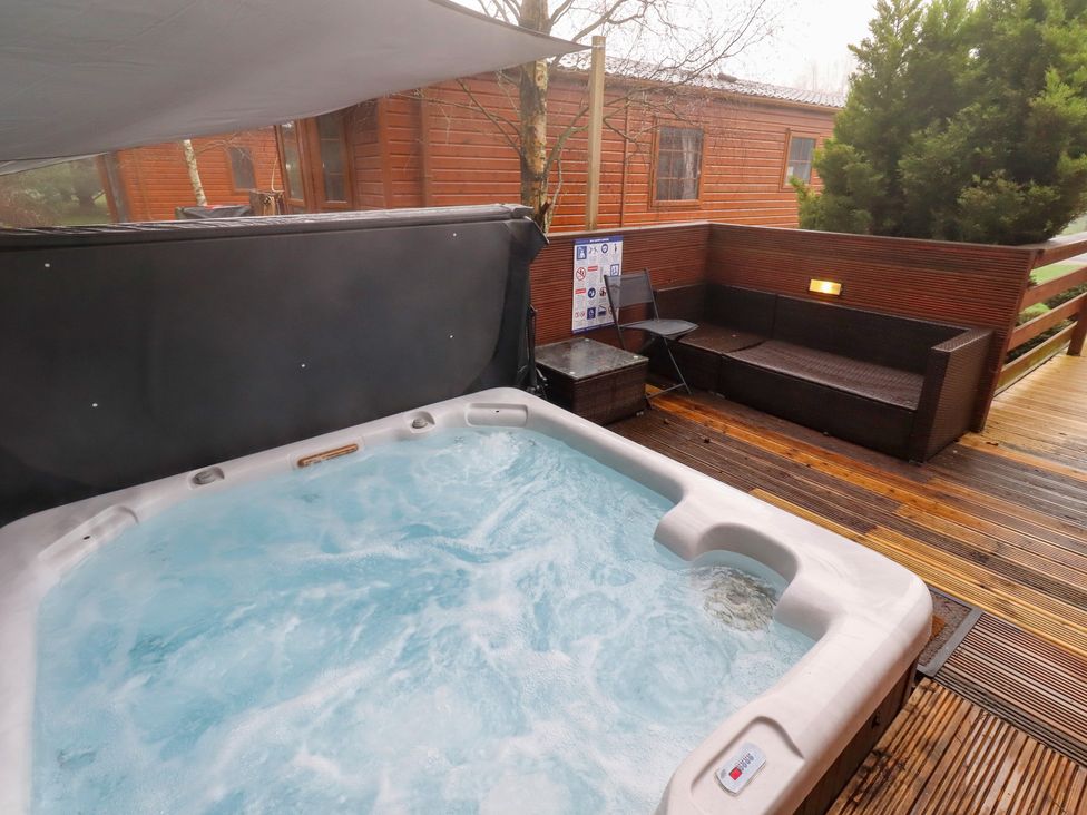 An outdoor area with a hot tub at Chloe's Cabin near Felmoor Holiday Park near Felton
