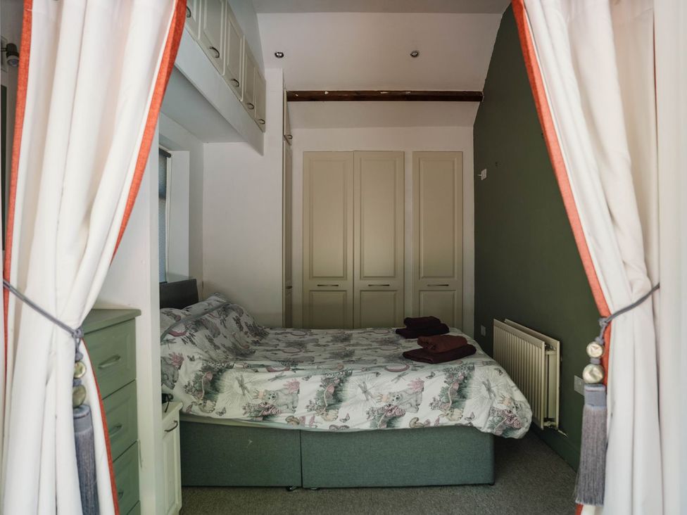 A bedroom with a bed and wardrobe at Carwinley Mill House Cottage near Longtown
