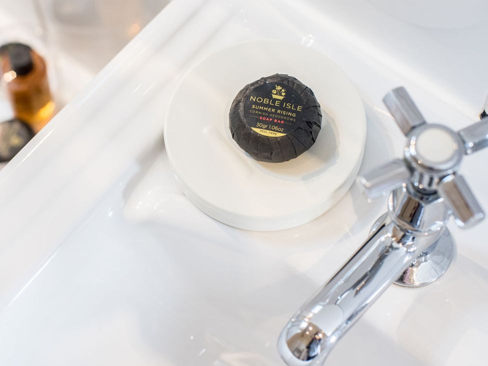 A soap bar on a dish near a faucet at Carwinley Mill House Cottage in Carwinley near Longtown