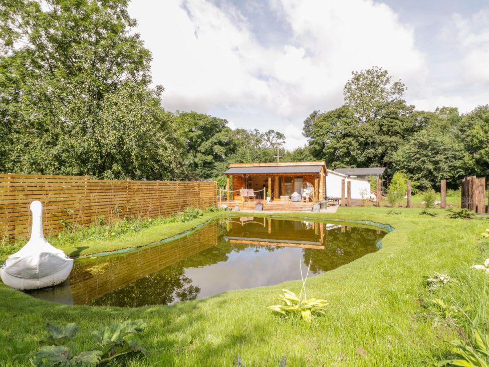 A garden with a pond and wooden structure at The Chard in Carlisle