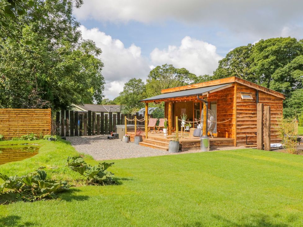 A wooden cabin with chairs and plants outside at The Chard in Carlisle