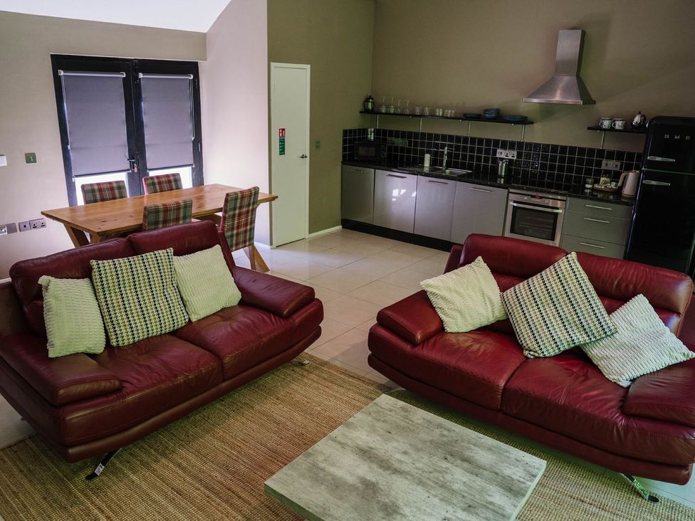 A living room with a sofa and dining area at The Heronry in Carlisle