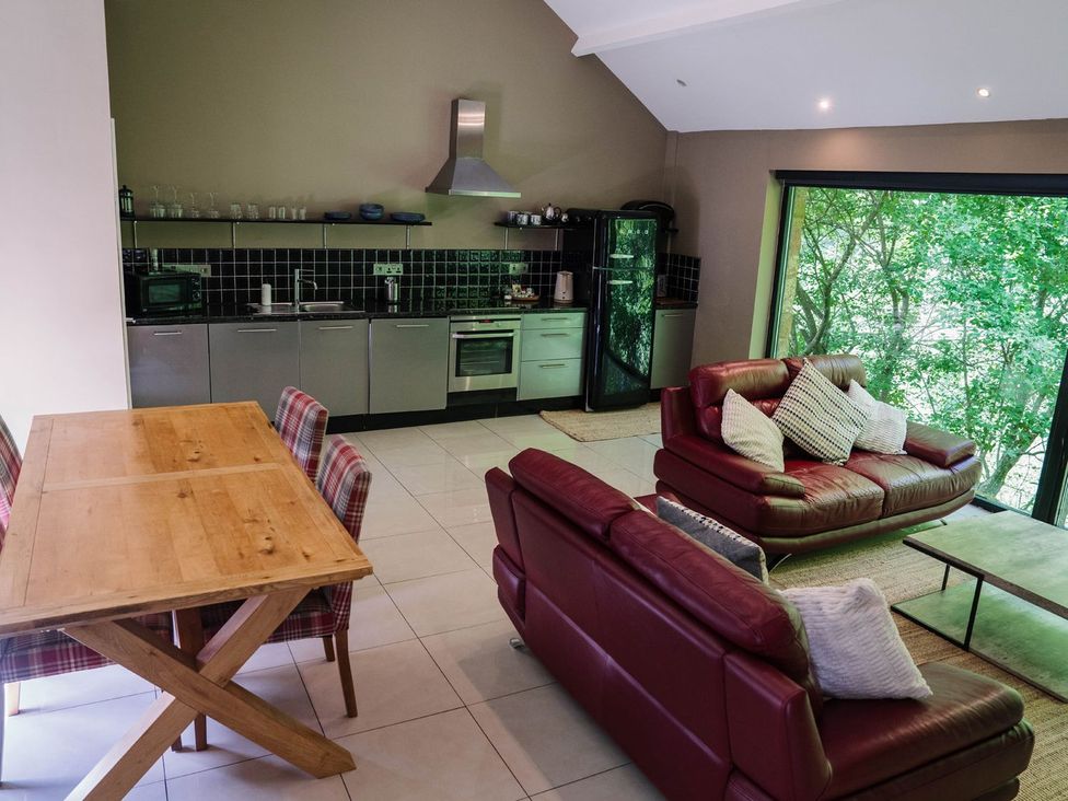 A kitchen and dining area with a table and seating at The Heronry in Carlisle