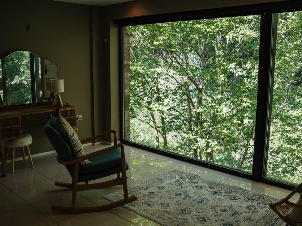 A living room with a chair and dressing table at The Heronry in Carlisle
