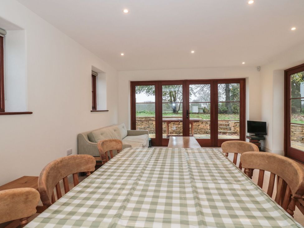 A dining room with a table and chairs at Manor Cottage in Carterton, Oxfordshire