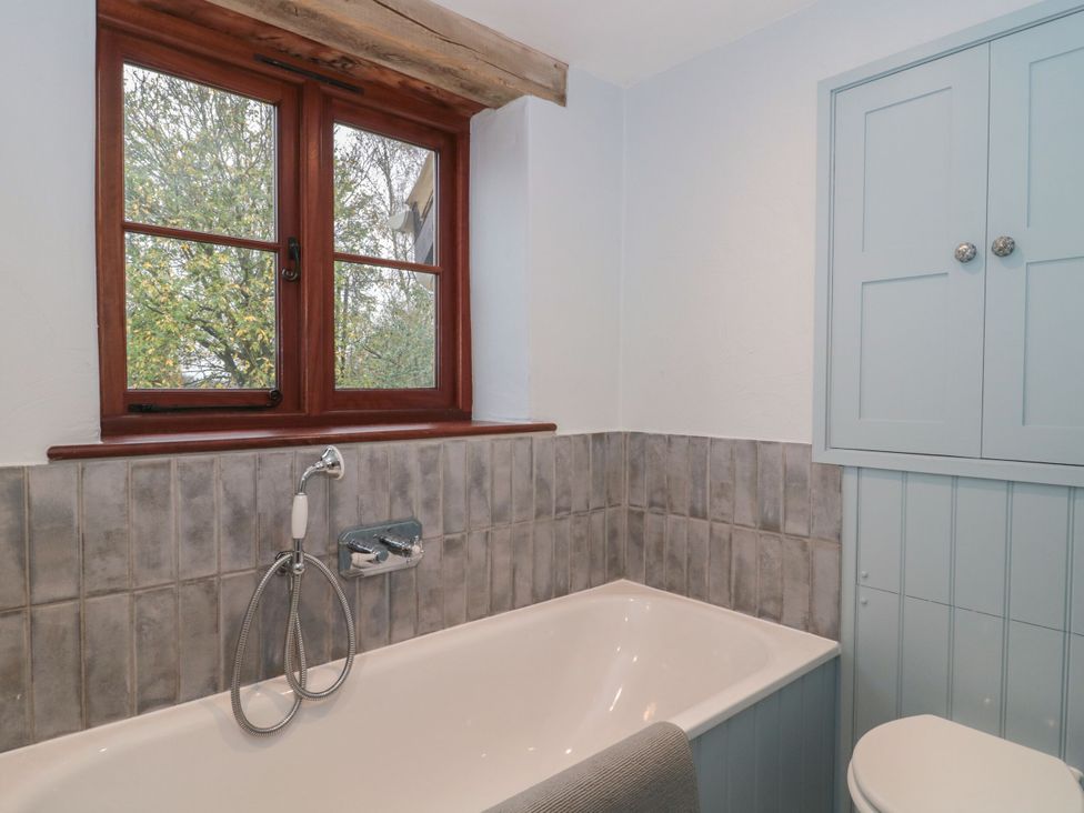 A bathroom with a bathtub and sink at Manor Cottage Carterton, Oxfordshire
