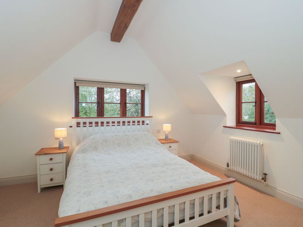 A bedroom with a bed and bedside tables at Manor Cottage in Carterton, Oxfordshire