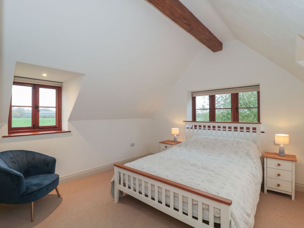 A bedroom with a bed and nightstands at Manor Cottage in Carterton, Oxfordshire
