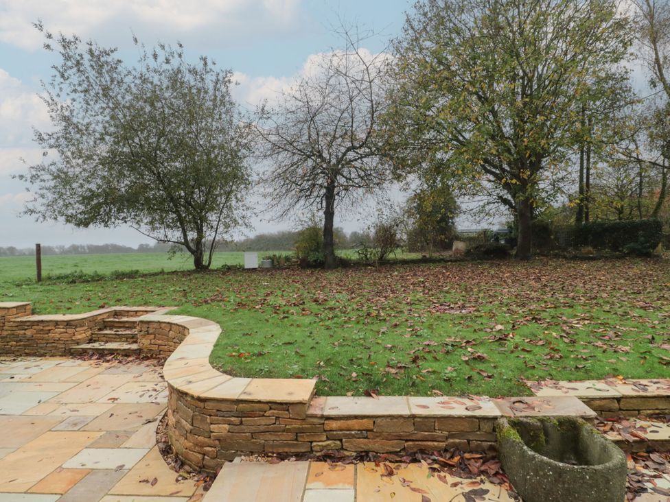 An outdoor area with grass and trees at Manor Cottage in Carterton, Oxfordshire