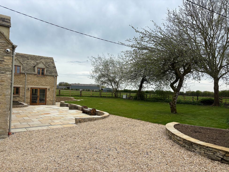 An outdoor area with a stone house and grass at Manor Cottage in Bampton, Oxfordshire