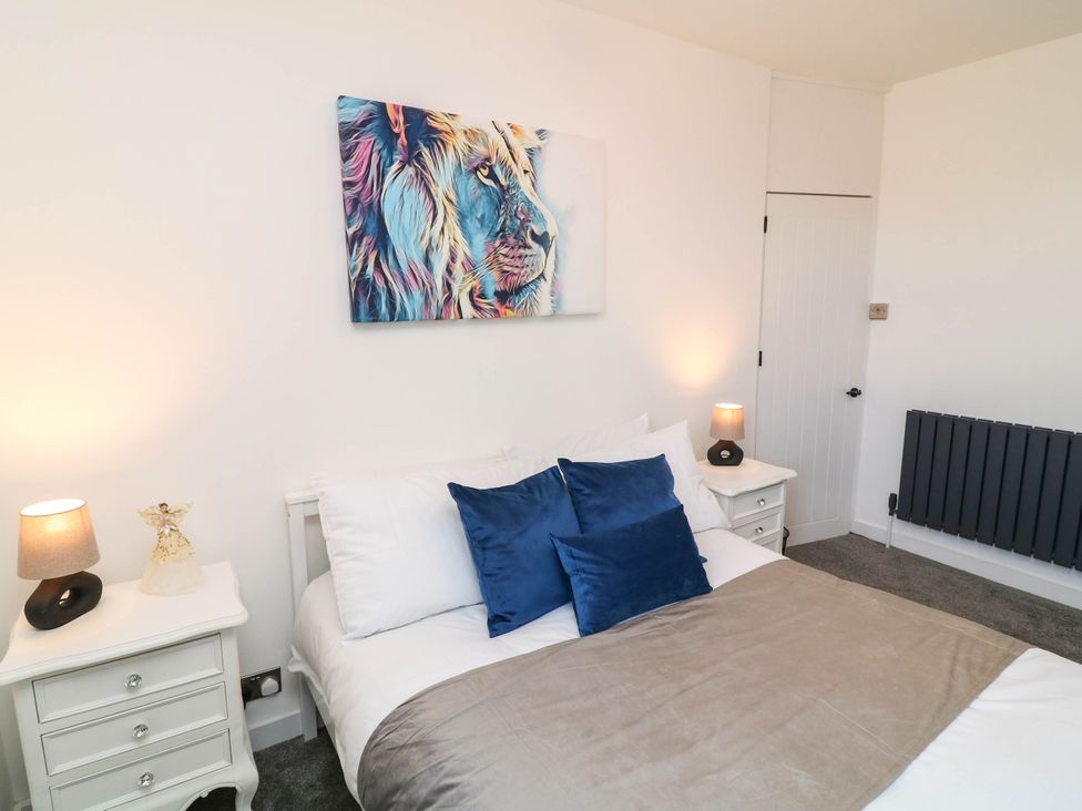 A bedroom with a bed and nightstands at 11 Regent Street Melton Mowbray