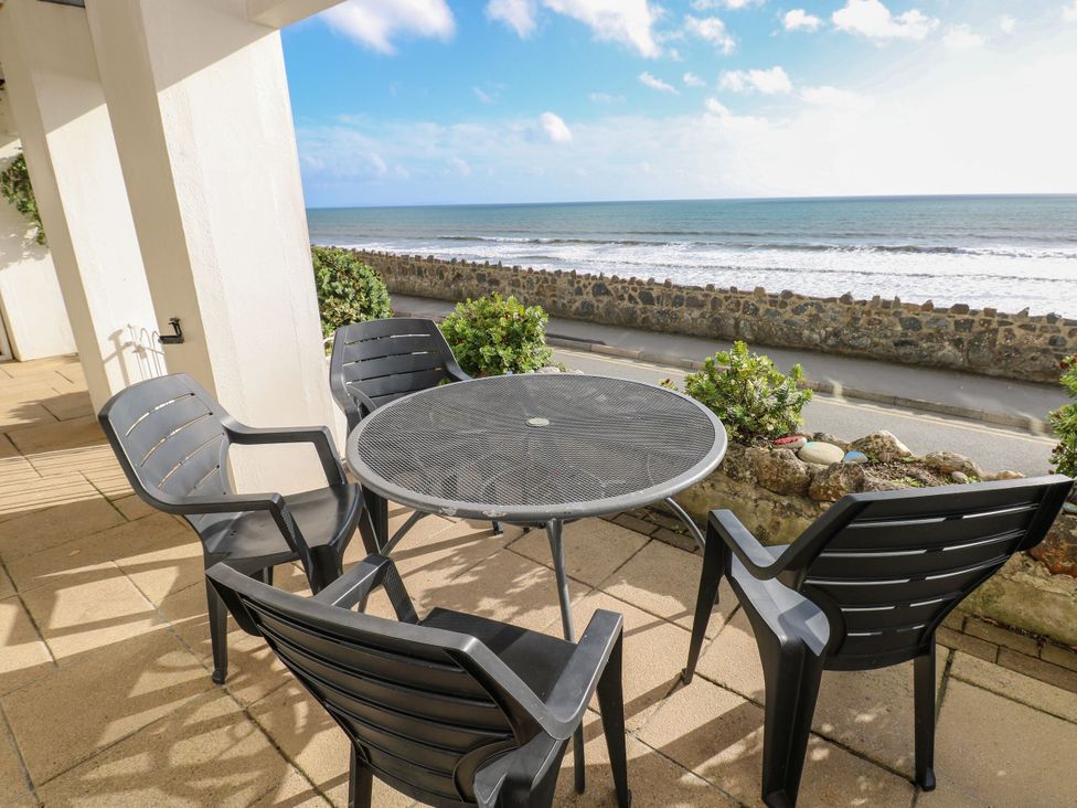 A table and chairs facing the sea at Rock House in Narberth
