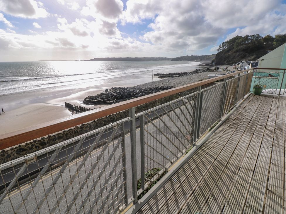 A balcony overlooking the ocean and beach at Rock House in Narberth