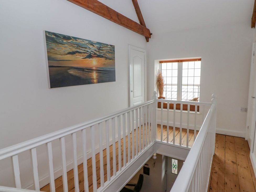 A hallway with a painting and a window at Rock House in Narberth