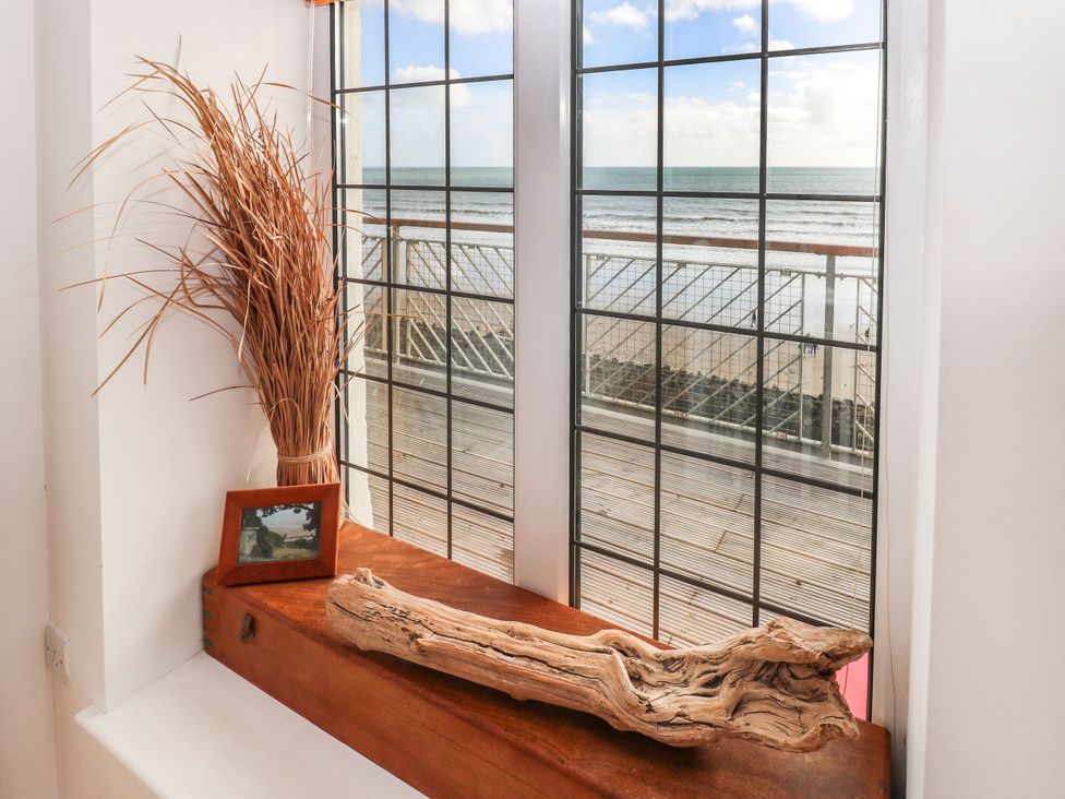 A living room with a window showing the sea at Rock House in Narberth