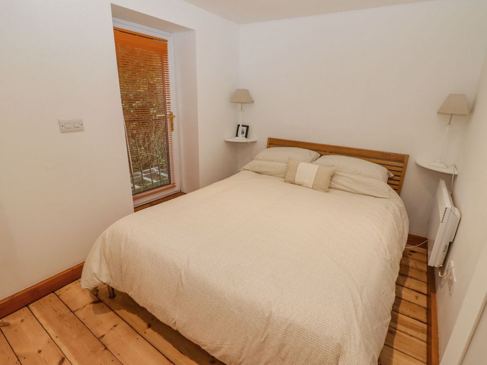 A bedroom with a bed and window at Rock House in Narberth