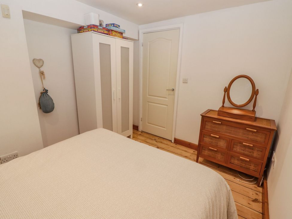 A bedroom with a bed and dresser at Rock House, Narberth
