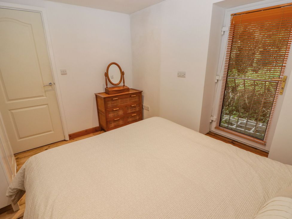 A bedroom with a bed and a dressing table at Rock House in Narberth