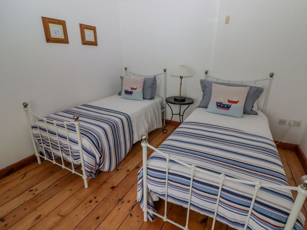 A bedroom with two single beds and a nightstand at Rock House in Narberth