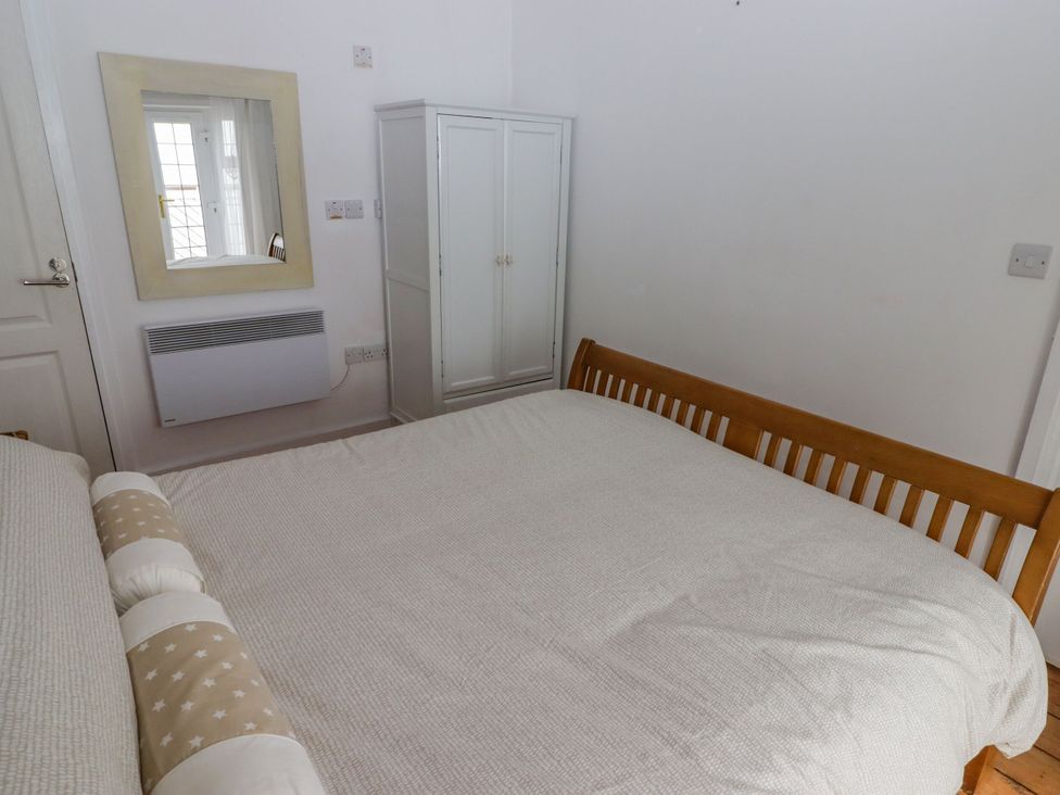 A bedroom with a bed and a wardrobe at Rock House in Narberth