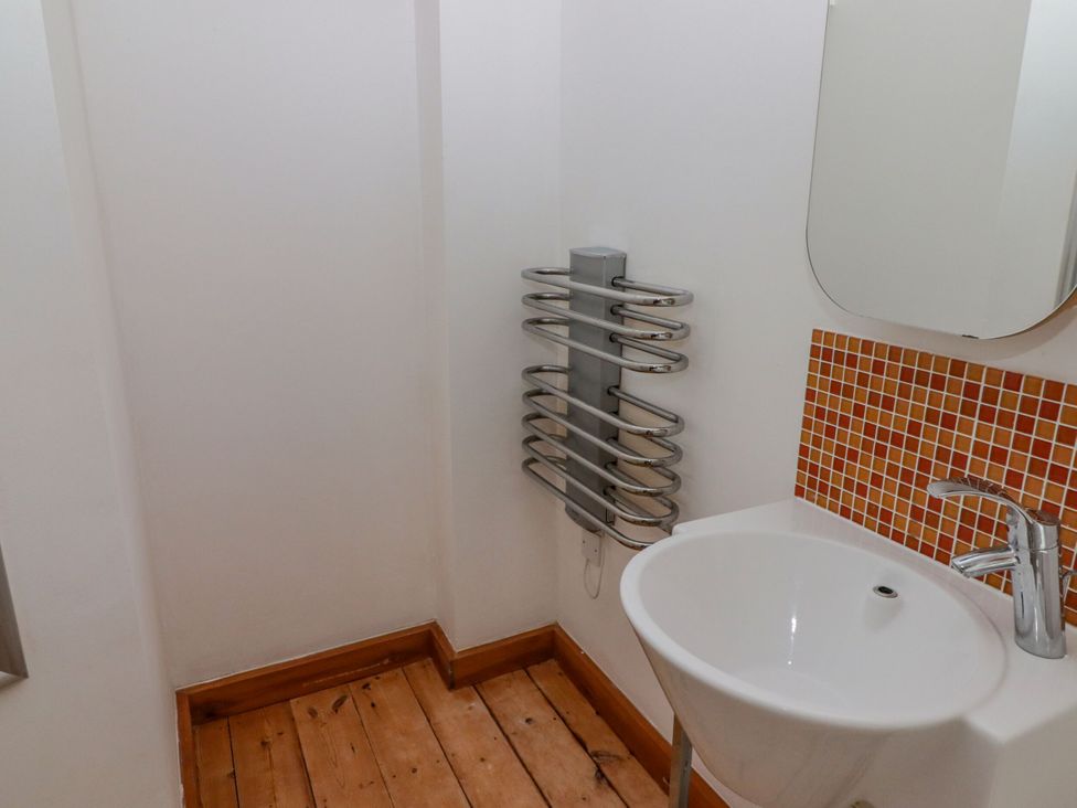 A bathroom with a wash basin and heated towel rail at Rock House in Narberth