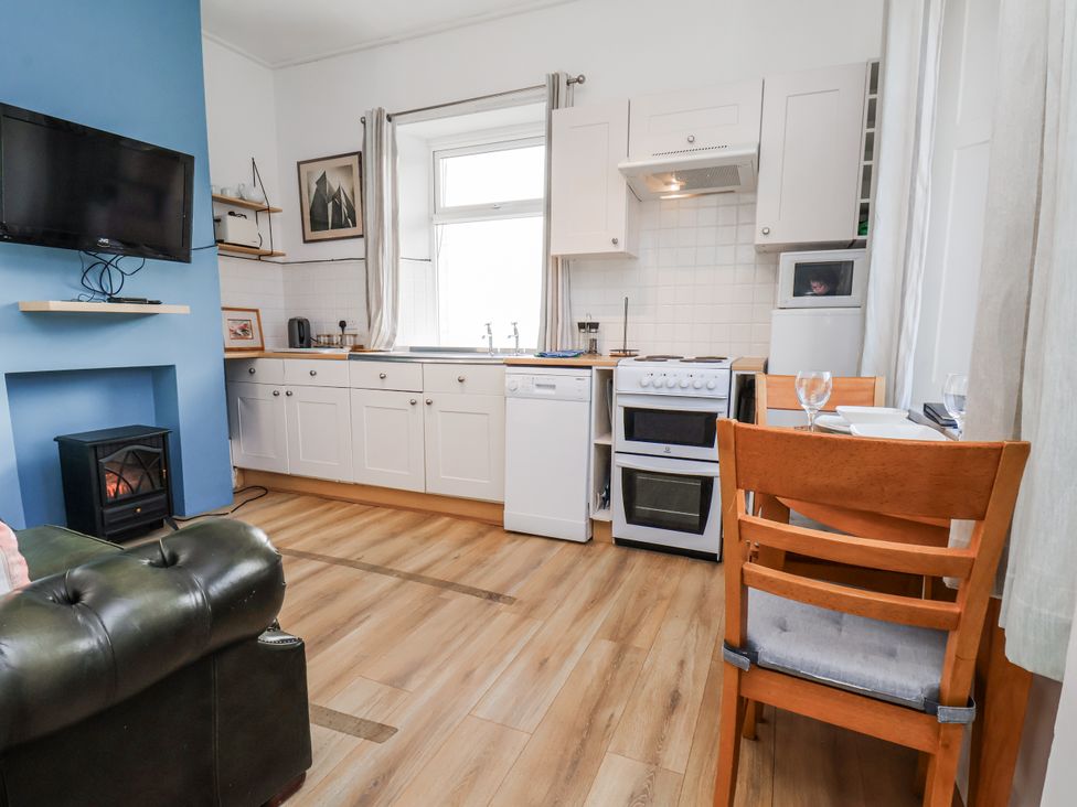 A kitchen with appliances and furniture at Hornblower Lodge in Whitby