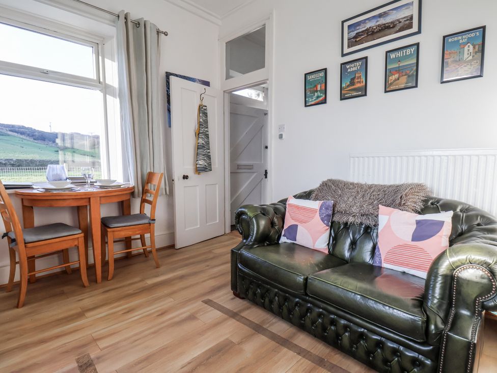 A living room with a sofa and dining table at Hornblower Lodge in Whitby