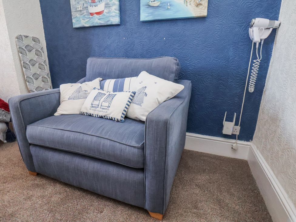 An armchair with cushions in the living room at Hornblower Lodge in Whitby